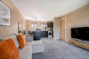 a living room with a couch and a flat screen tv at Waterlily Apartment - Beautiful 1-bed with overlooking balcony in Nottingham