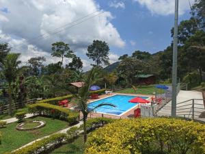 ein Resort mit Pool und Bergen im Hintergrund in der Unterkunft Cabaña Mi refugio in Guayabal de Síquima