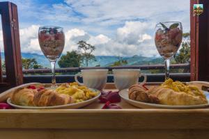 a table with two plates of food and two glasses of wine at Cabaña Mi refugio in Guayabal de Síquima