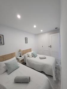 サンルーカル・デ・バラメダにあるTERRAZAS DE DOÑANAの白い壁の客室内のベッド2台