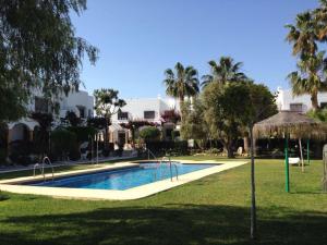 ein Swimmingpool in einem Garten mit Palmen in der Unterkunft CM - Campomar Mojacar in Mojácar