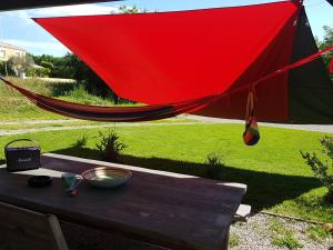 amaca rossa appesa a un tavolo in un cortile di Maison chaleureuse a Belleville-sur-Vie