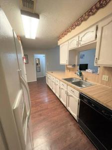 a kitchen with white cabinets and a black refrigerator at Super Cozy 4 Bedroom - Sleeps 10 Great for families and professionals in Katy