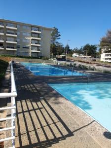 an empty swimming pool in front of a building at Hermoso Departamento in El Tabo