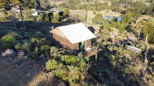 einen Blick über ein Holzhaus mit weißem Dach in der Unterkunft Pousada Sitio Bella Vista in Urupema