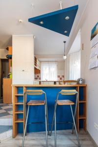 a kitchen with a blue island and two stools at Energetyczny Zakątek in Krzeszna