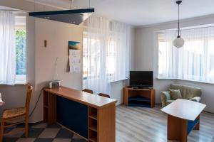 ein Wohnzimmer mit einem Schreibtisch und einem TV in der Unterkunft Energetyczny Zakątek in Krzeszna