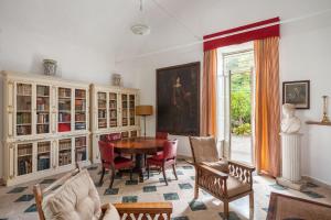 uma sala de estar com uma mesa e cadeiras e uma janela em Vero Sicily - Sicilian Garden Cottages em Bagheria