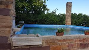 een zwembad in een bakstenen muur met twee potplanten bij Arhodico Simou mansion in Kambos