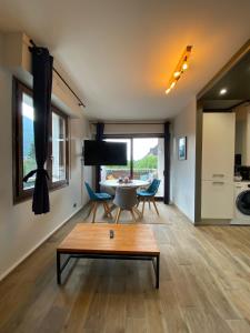 - un salon avec une table et une salle à manger dans l'établissement Le Malaga - parking & balcon, à 500m du lac !, à Annecy