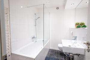 baño blanco con ducha y lavamanos en Komplette 2 Zimmer Wohnung Zentral neben Oktoberfest, en Múnich