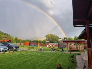 un arco iris sobre un parque infantil con bicicletas para niños en Kincses Panzió en Praid