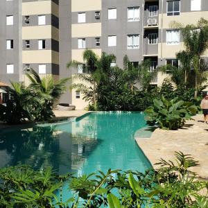 a swimming pool in front of a building at Apartamento Resort Palmeiras 2 com 03 Quartos Ubatuba in Ubatuba