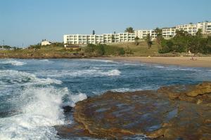 a view of a beach with waves and buildings at Laguna La Crete 28 in Uvongo Beach