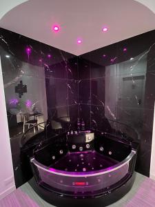 eine lila Badewanne in einem Zimmer mit lila Lichtern in der Unterkunft Domus Flavia B&B in Rom