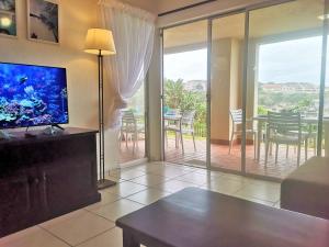 a living room with a television and a table with a dining room at Laguna La Crete 28 in Uvongo Beach