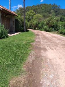 an empty dirt road next to a house at Chalé MJF in Monte Verde