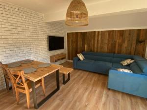 salon z niebieską kanapą i stołem w obiekcie Apartament Chleb i Wino w mieście Krynica Zdrój