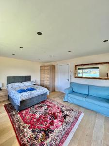 a bedroom with a bed and a blue couch at Loch Morar Private Suite in Mallaig