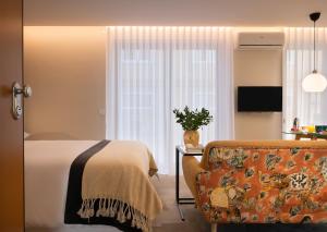 - une chambre avec un lit, un canapé et une télévision dans l'établissement Wanderlust, by Bolhão Residences, à Porto