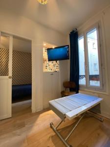 Pokój z łóżkiem i telewizorem z płaskim ekranem w obiekcie Cosy courcelles w Paryżu