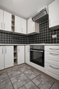 a kitchen with white cabinets and a stove at Flat 1 Bellevue in Bristol