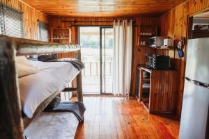 Zimmer mit 2 Etagenbetten und einem Kühlschrank in der Unterkunft Amperda Log Cabins in Bergheim