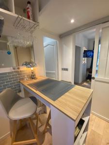 a kitchen with a counter and a table and a chair at Cosy courcelles in Paris