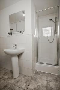 a white bathroom with a sink and a shower at Flat 1 Bellevue in Bristol