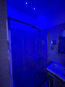 a bathroom with a glass shower with a blue light at Domus Flavia B&B in Rome