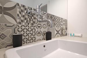 a bathroom with a sink and a faucet at City Hall view Apartment Liberec in Liberec