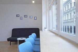 a living room with blue chairs and a couch at City Hall view Apartment Liberec in Liberec +10 photos
