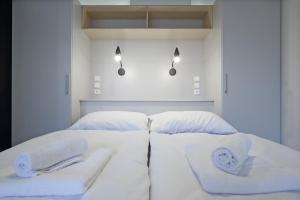 białe łóżko z dwoma białymi ręcznikami w obiekcie City Hall view Apartment Liberec w mieście Liberec