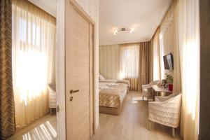 Habitación de hotel con cama y sala de estar. en Hotel Kera en Tiflis
