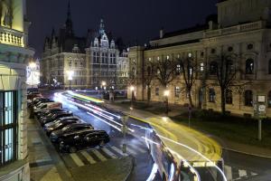a row of cars parked on a city street at night at City Hall view Apartment Liberec in Liberec