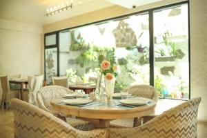 uma mesa de madeira com cadeiras e uma mesa com flores em Hotel Kera em Tbilisi