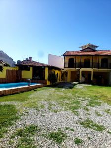 a yard in front of a house with a swimming pool at Pousada Amarela Cabo Frio in Cabo Frio