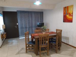 een eetkamer met een tafel en stoelen en een televisie bij Terracota lodge in Guaymallen