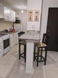 a kitchen with a table and two chairs at Terracota lodge in Guaymallen +4 photos