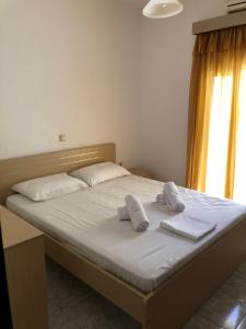 łóżko z dwoma białymi poduszkami na górze w obiekcie Blue Sky Apartments w mieście Makry Gialos