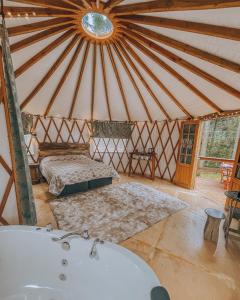 um quarto com duas camas e uma banheira numa tenda em Estancia Las Araucarias em Canela