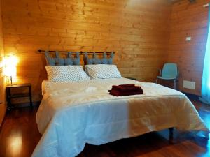 una camera da letto con un letto bianco con una parete di legno di Chalet Collalto con Piscina a Cerratina Altre 35 foto
