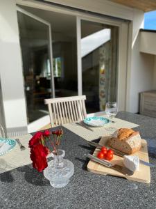 una mesa con un plato de pan y tomates. en Beautiful apartment with fantastic views en Oberägeri