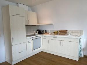 a white kitchen with white cabinets and a sink at Beautiful apartment with fantastic views in Oberägeri