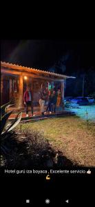 un grupo de personas de pie en el porche de una casa en GhuRu Hotel Campestre en Firavitoba