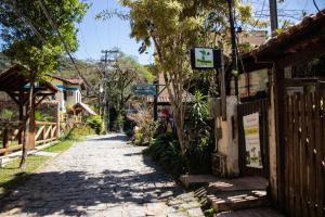 eine Kopfsteinpflasterstraße in einem Dorf mit einem Zaun in der Unterkunft Hostel Papagaio in Abraão