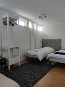 1 dormitorio con 2 camas individuales y alfombra en House. 80m2, near Lake, with car charge., en Sommarbo