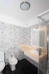 a bathroom with a sink and a toilet and a shower at Praia Mar (sea view) by STAY Madeira Island in Ponta do Sol