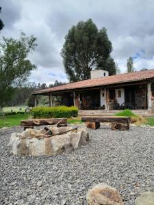 un edificio con troncos frente a un edificio en GhuRu Hotel Campestre en Firavitoba