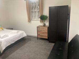 Lancing Apartments - Spacious 2 Bed - Sleeps 6 - Burnham Village في سلاو: غرفة نوم مع سرير وكابينة ونبات الفخار